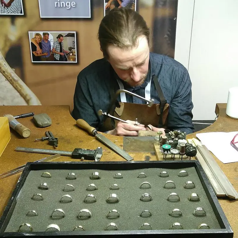 Goldschmied bei der Arbeit am Werkbrett